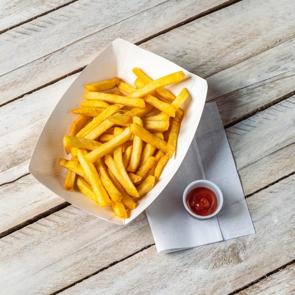 A white paper tray filled with golden french fries, with a side of ketchup on a napkin.